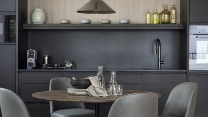 Moderner Küchenbereich mit runden Tisch und grauen Stühlen