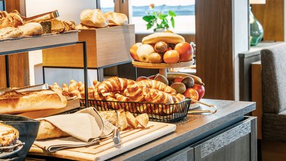 Verschiedene Brote, Croissants und Obst auf einem Buffet-Tisch