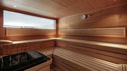 moderner sauna innenraum mit holzvertäfelung und steinofen