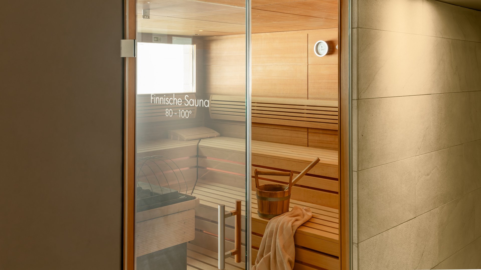 Finnish sauna with wooden benches and bucket in wellness area
