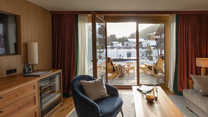 Gemütlicher Raum mit Blick auf Terrasse und verschneite Berglandschaft