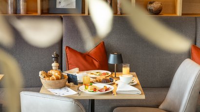 Gemütlicher Frühstückstisch mit Kaffee, Gebäck und Saft in modernem Café