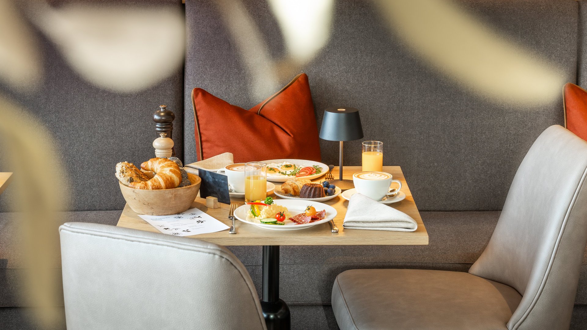 Gemütlicher Frühstückstisch mit Kaffee, Gebäck und Saft in modernem Café